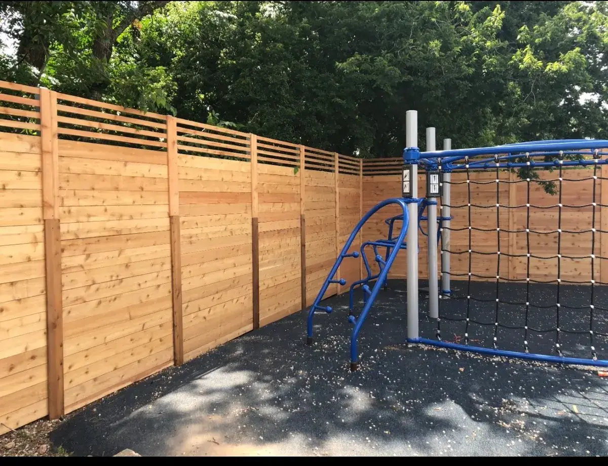 Horizontal cedar fence around a playground