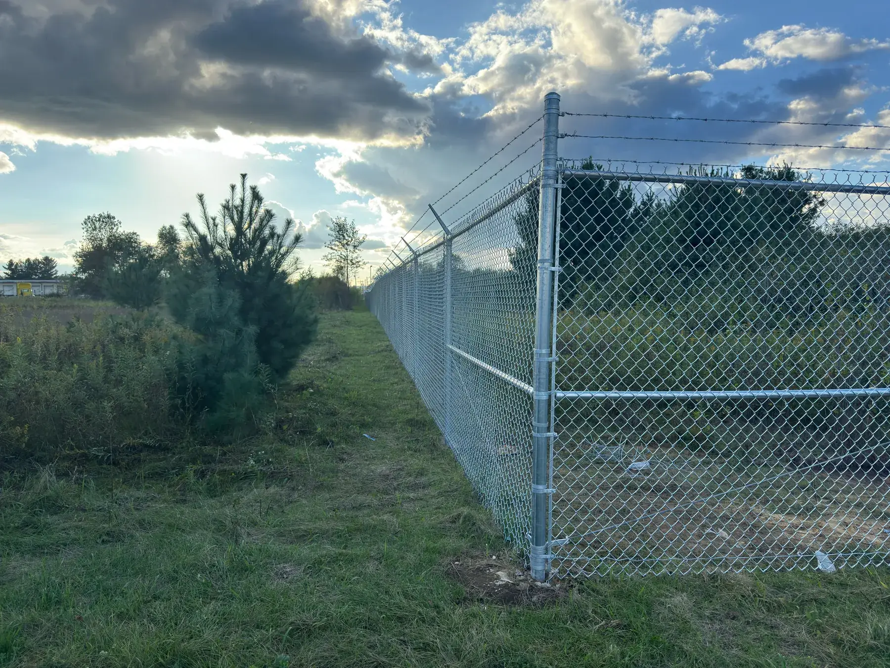 Secured perimeter fence line at golden hour