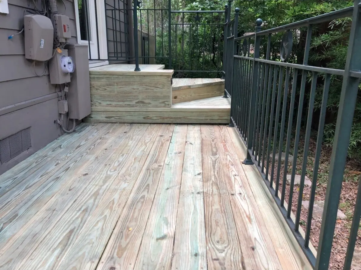 Freshly built pressure-treated deck with metal railing
