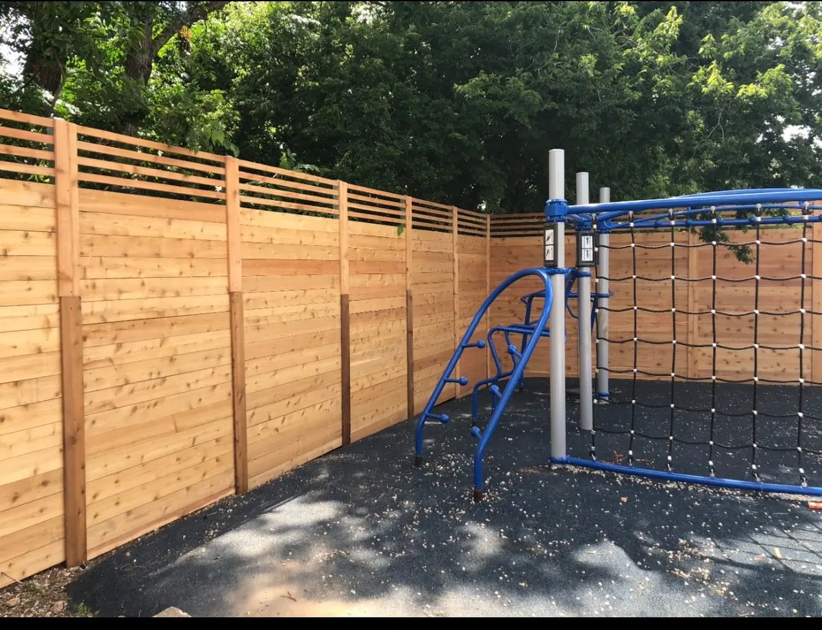 Horizontal cedar fence around a playground
